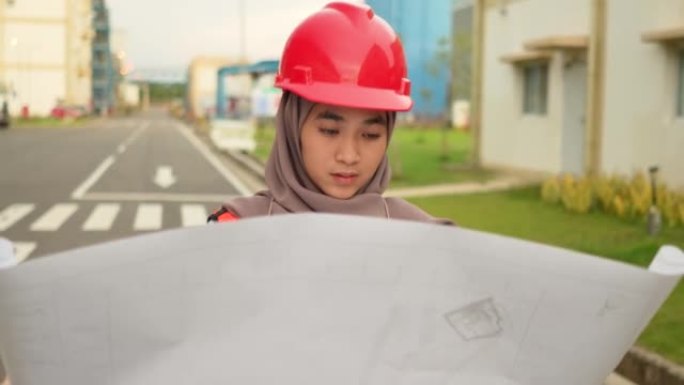 工程师穆斯林妇女检查建筑工地的蓝图