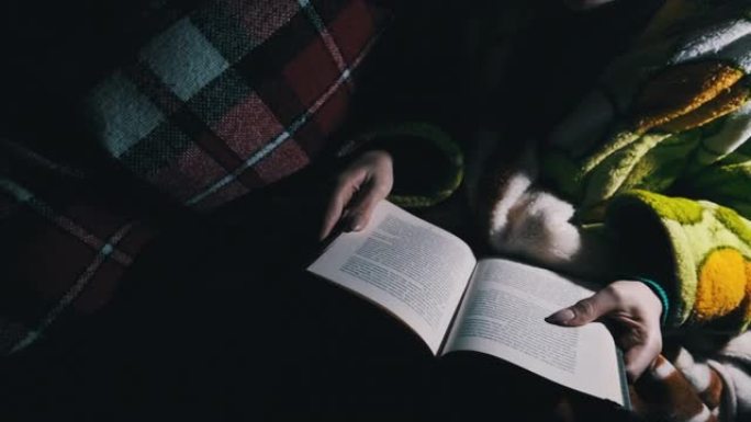 女人晚上在灯笼的灯光下躺在沙发上看书