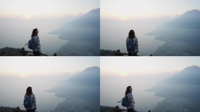 日落时站在危地马拉阿蒂特兰湖背景上的女人