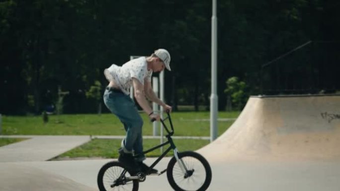 滑板场的城市极限。一个骑自行车的年轻人表演技巧和跳跃。极端