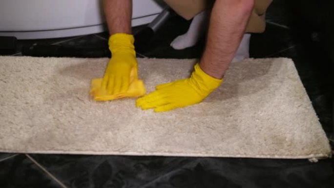 用特殊的去污剂清洁地毯用清洁剂去除地板上的污渍。清洁工在工作