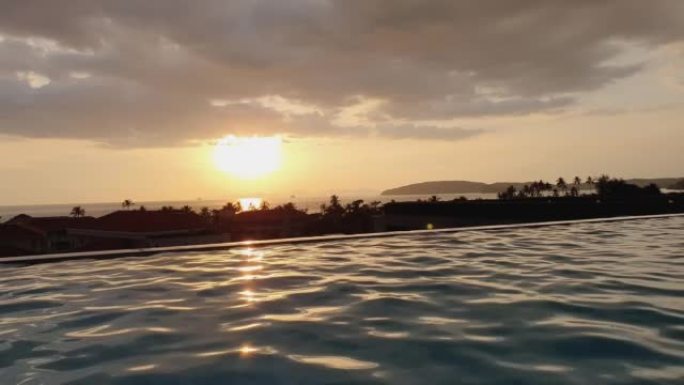 Beautiful sunset over luxury swimming pool at a re