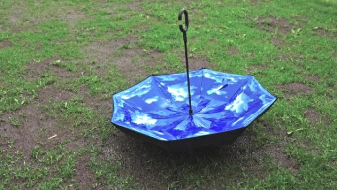 短片显示雨天气和绿色草坪上的雨伞。雨季概念。