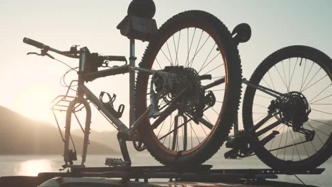 带有两辆自行车的汽车安装在乡村道路上的自行车车顶托架上