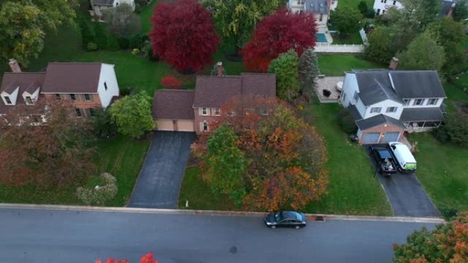 美国附近的房子。傍晚时分的秋天树木。空中卡车射击。