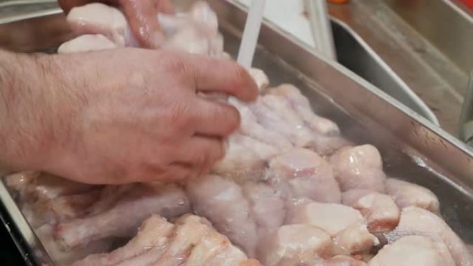 一家快餐店的厨师通过从水龙头中倒水来解冻鸡腿，并用手打破冷冻的鸡腿。烧烤用腌肉