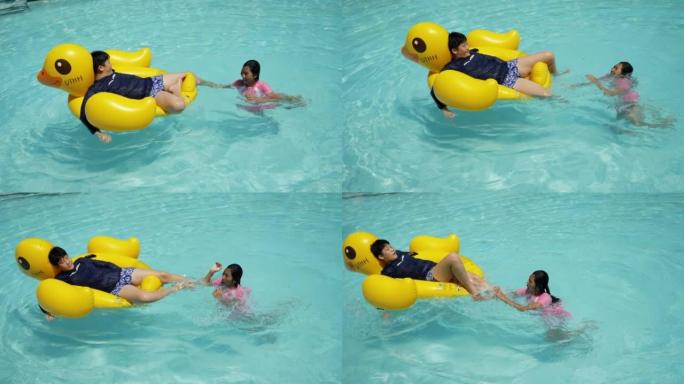 快乐的亚洲儿童在度假期间与家人在酒店或度假村一起在游泳池里玩黄鸭橡皮筏，生活方式理念。