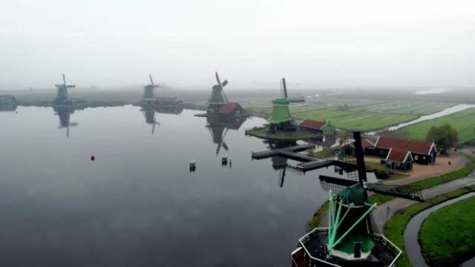 冬季，Zaanse Schans风车村的木制风车与foggylandscape，雾覆盖了木制历史风车