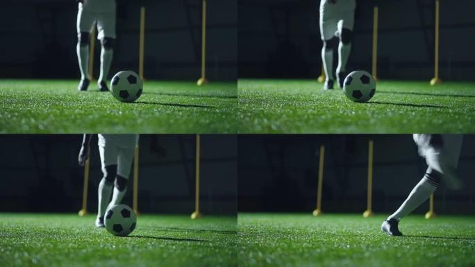点球，熟练的职业足球运动员的腿和球场上的球的特写镜头，慢动作