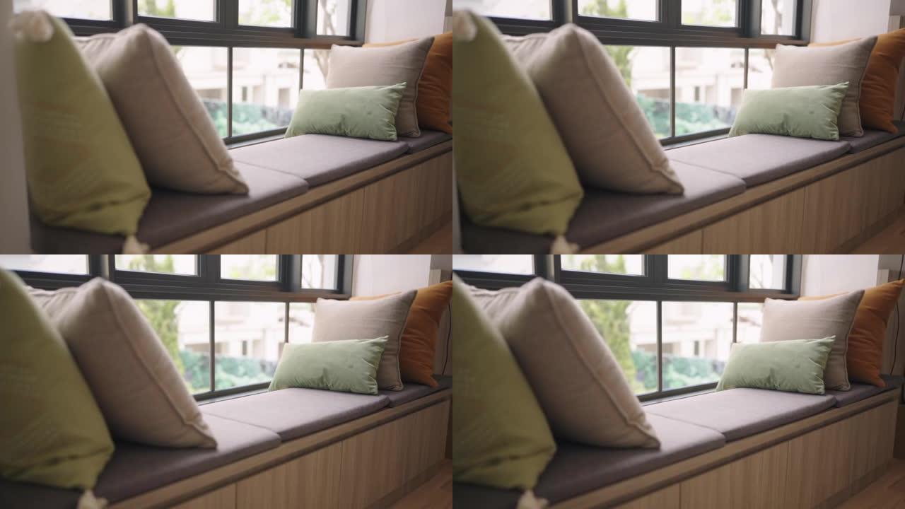 多莉特写彩色软枕头靠垫布置在沙发沙发上，带模糊花园景观，透明窗帘，客厅家居室内设计理念