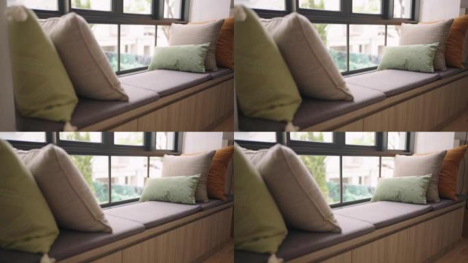 多莉特写彩色软枕头靠垫布置在沙发沙发上，带模糊花园景观，透明窗帘，客厅家居室内设计理念