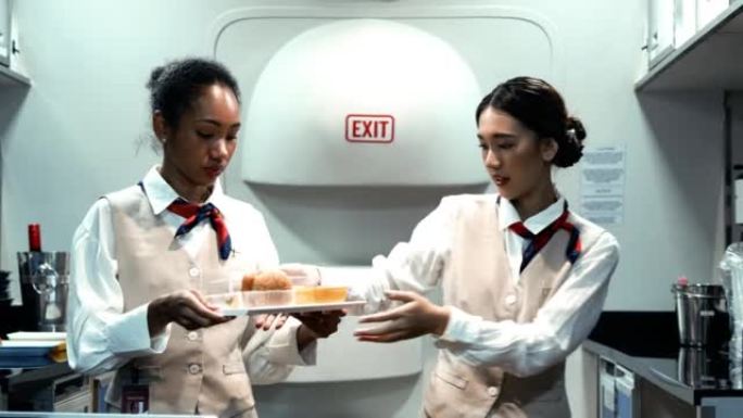 两位亚洲美女空姐为头等舱和商务舱乘客准备食物和饮料。美丽的空中小姐或空乘在飞机上为乘客服务。航空公司