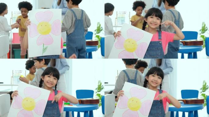 快乐的小女孩在幼儿园教育学校的教室里画彩书后展示图片。多民族幼儿教师和学生在教室里。幼儿园和学习理念