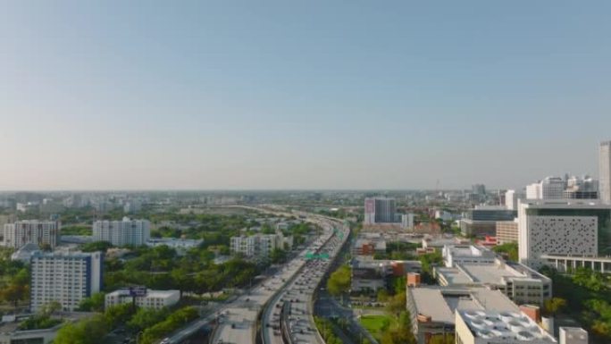 大城市繁忙的多车道高速公路的航拍画面。下午晚些时候拍摄了平坦景观中的城镇交通基础设施。美国迈阿密