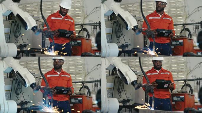 工程师非裔美国人致力于控制和编程制造业中的自动化机器人手臂机器。