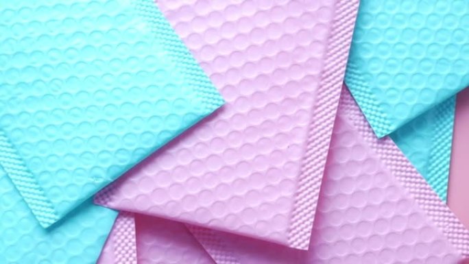 桌子上的粉色和v蓝色纸气泡信封