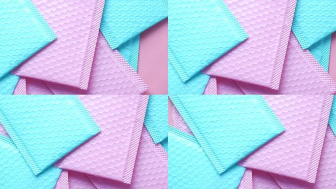 桌子上的粉色和v蓝色纸气泡信封