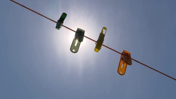 蓝色的天空和明亮的太阳在字符串上的彩色剪辑