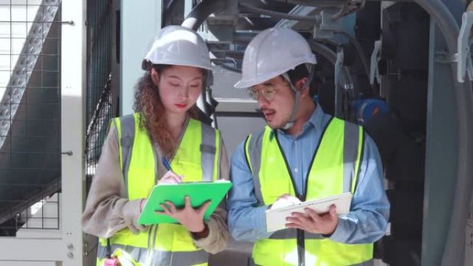 工程师正在检查行业冷冻水风机盘管机组空调是大型工业建筑的水冷却塔空气冷却器暖通系统控制空气系统