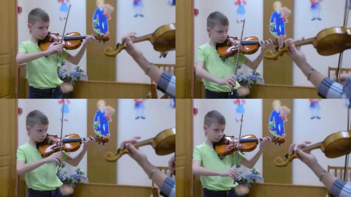 儿童男孩学生在音乐学校的音乐课上与老师拉小提琴。