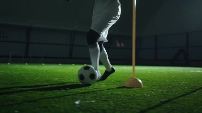 职业足球运动员在体育场练习运球技巧，脚和球的特写镜头