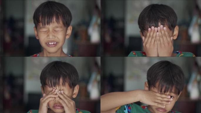 男孩哭着遮住脸的手的肖像。