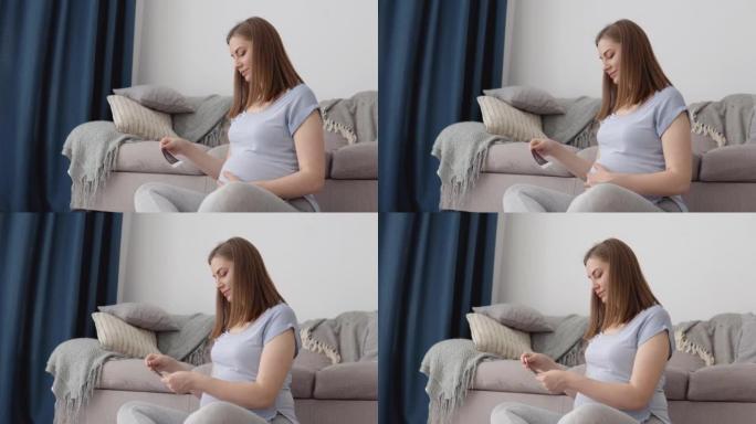 孕妇看着未出生婴儿的胎儿的第一张照片。监测怀孕的现代技术。通过超声确定孩子的性别