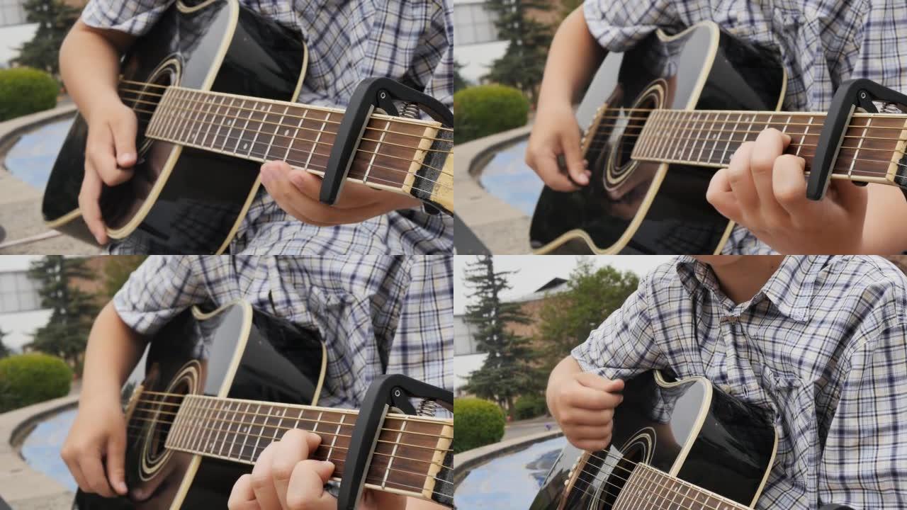肖像: 一位穿着衬衫的可爱的高加索男孩吉他手将capadastr放在吉他的脖子上，并开始用塑料拨片弹