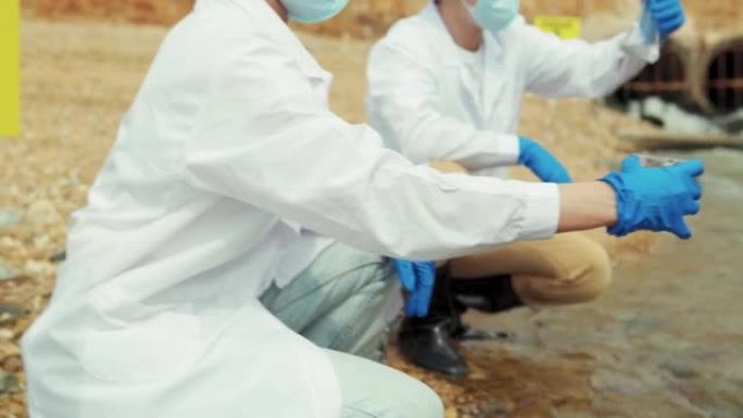 两名生态学家检查污染地区的污水