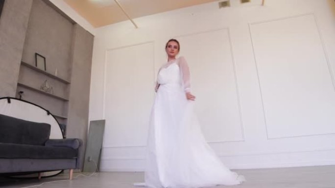 一个穿着白色婚纱的女孩摆姿势，rki在腰带上挥舞着下摆。