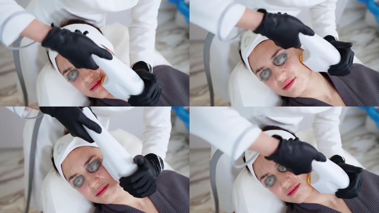 美容程序在现代美容诊所中，专家美容师正在使用光疗仪