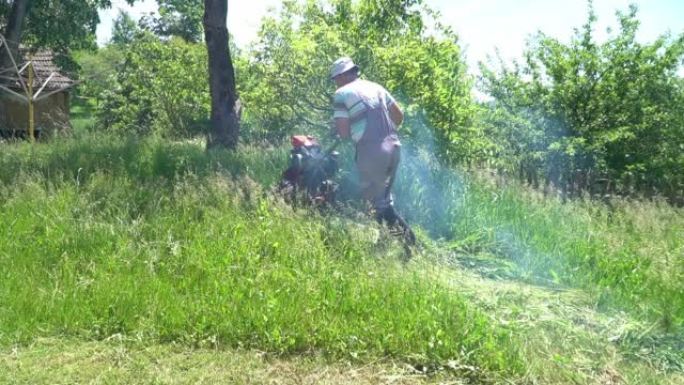视频显示，一个穿着工作服的男人头上戴着帽子，在院子里用摩托车耕种机割草