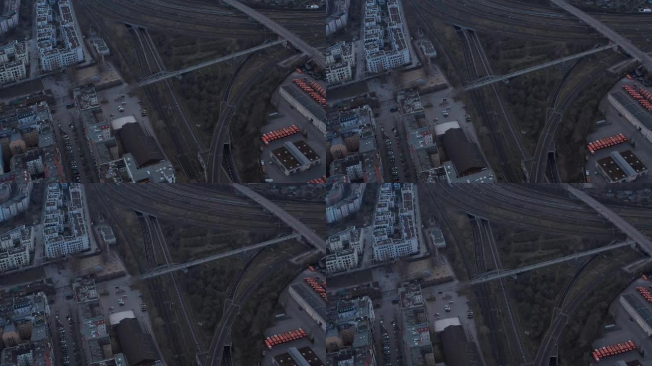 空铁路线的空中慢动作视图，人们步行在德国柏林的住宅和清晨停放的车辆附近的桥梁上行走