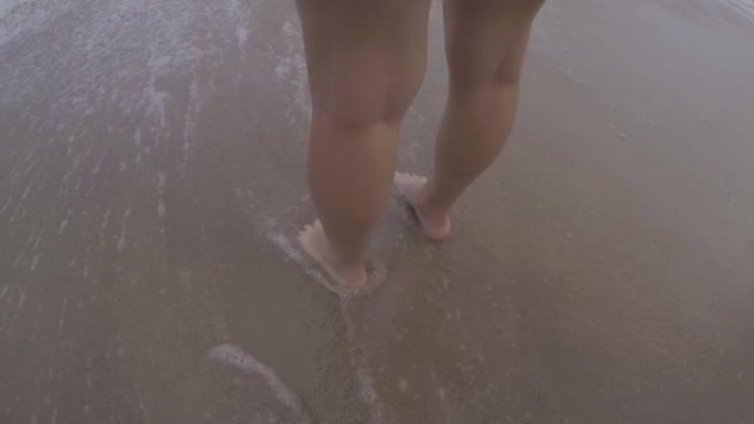 脚在海滩上。大海把脚弄湿了。巴西海滩