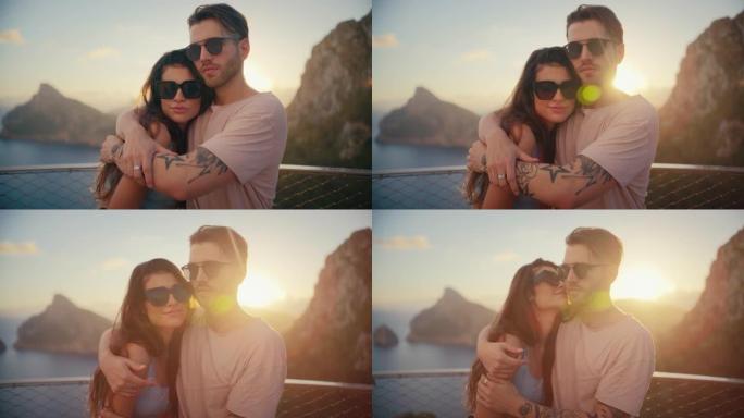 浪漫的夏天。夫妇在度假时戴着墨镜坐在长凳上，背景是金色的日落。温暖的拥抱