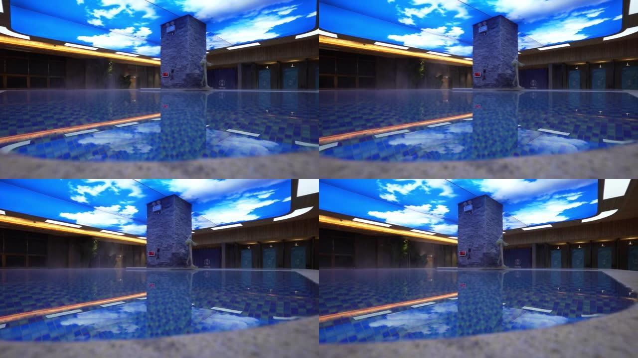 一个空的水疗中心，有一个蓝色的游泳池和天花板