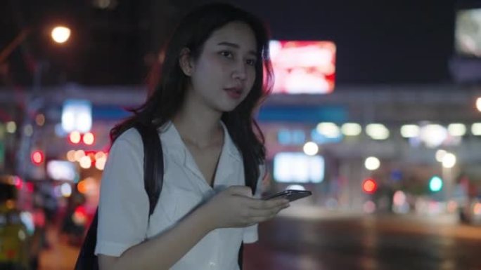 亚洲女性晚上用智能手机叫出租车