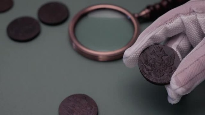 钱币学。木制桌子上的旧收藏硬币。黑暗背景。