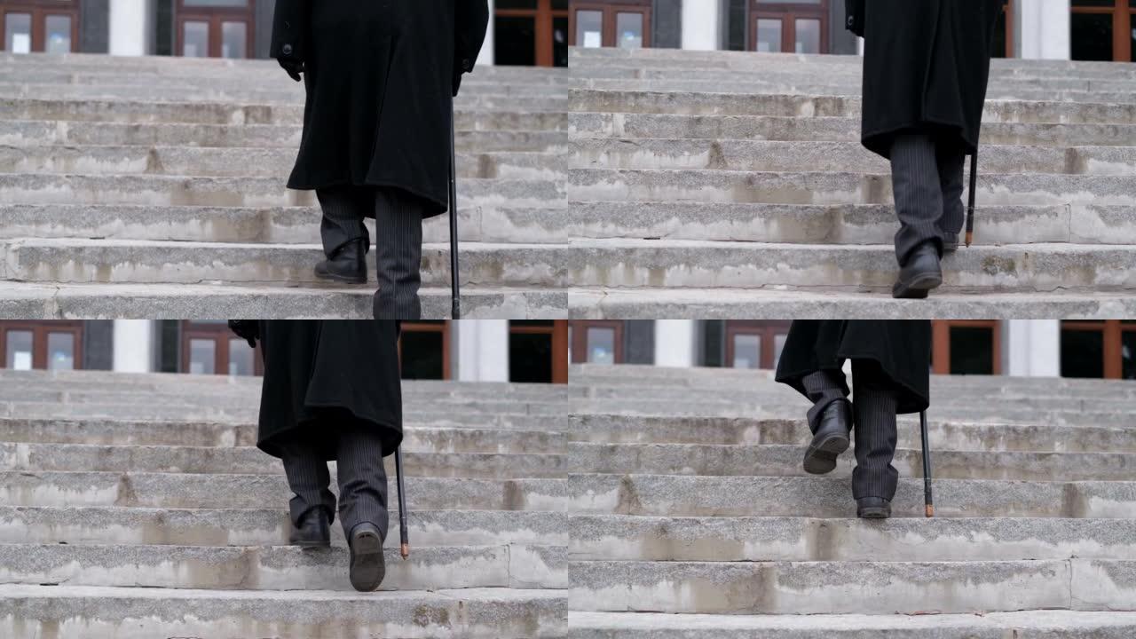 一位穿着黑色外套的老爷爷爬楼梯，步履艰难。80岁的老人