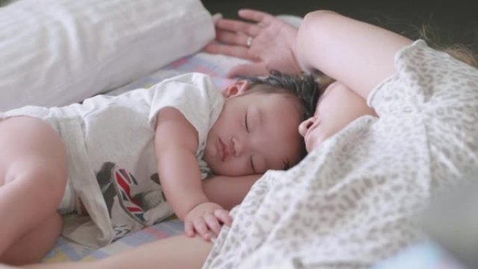 亚洲妈妈在家和男婴睡觉。