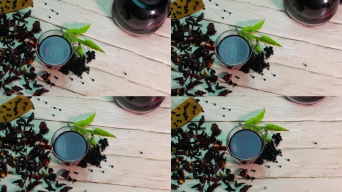 运动中的顶视图在木板上的透明杯子中的红香茶，接骨木茶，草药酊剂，顺势疗法