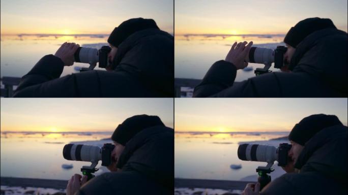 摄影师对焦长镜头的相机拍摄日落