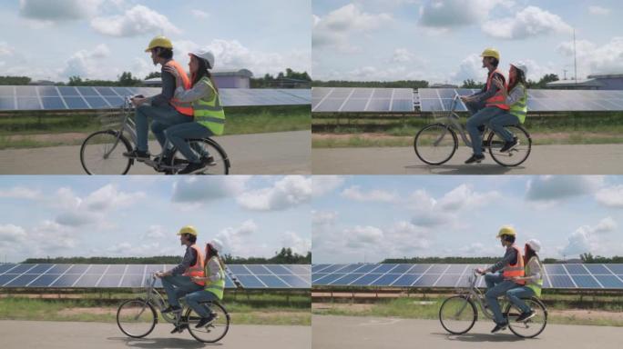 两名工人夫妇在太阳能农场骑自行车，并有乐趣检查太阳的运作和清洁光伏太阳能电池板。生态系统概念