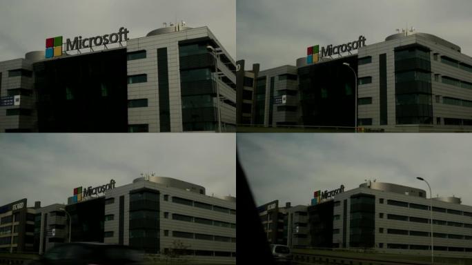 波兰华沙，2022年4月30日: 骑在城市道路旁经过微软大楼