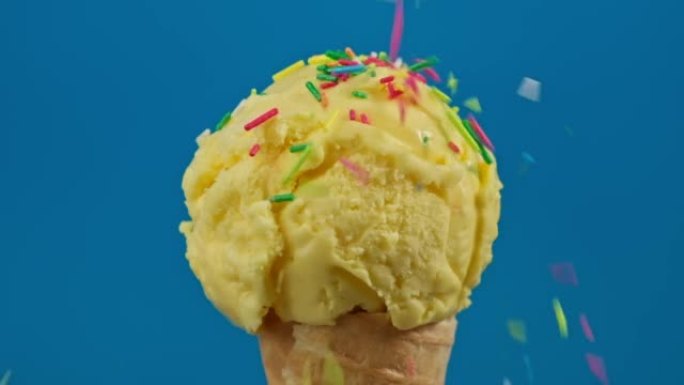 五颜六色的洒落在香蕉冰淇淋上。蓝色背景的冰淇淋。
