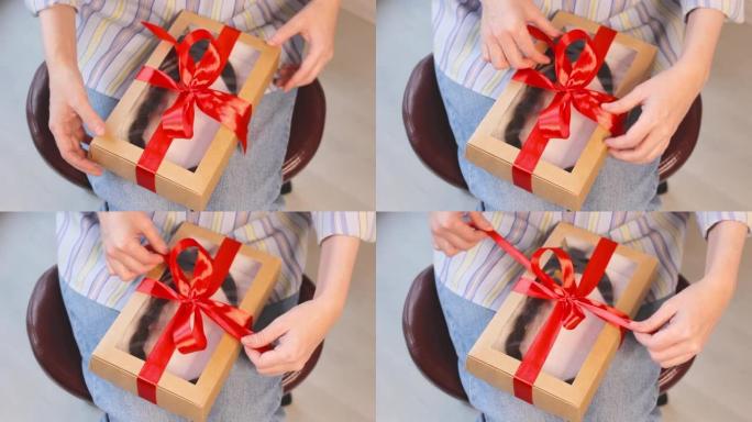 女人用天然切割辫子在礼品盒上解开丝带，捐赠理发