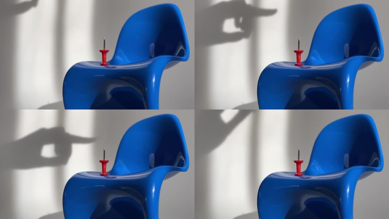 白色背景上有红色纸针的蓝色椅子。白色背景上的痔疮问题概念。
