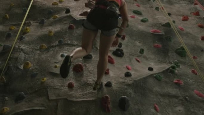 慢动作，从攀岩中向下移动，而belayer支持她。