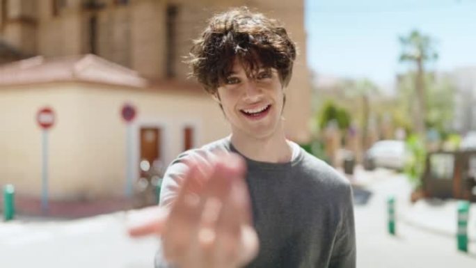 年轻的西班牙裔男子微笑着自信地在街上用手指做着手势
