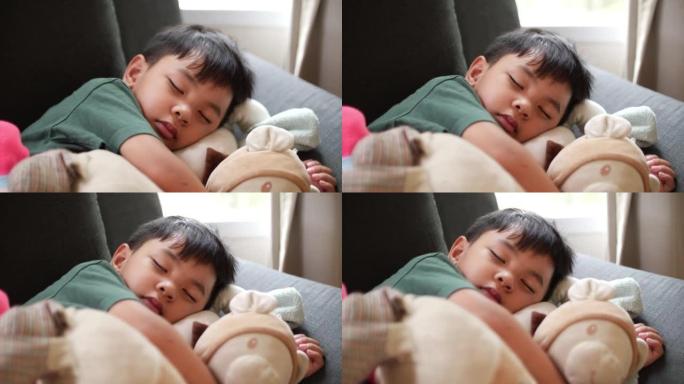 亚洲男孩和他的泰迪熊睡觉